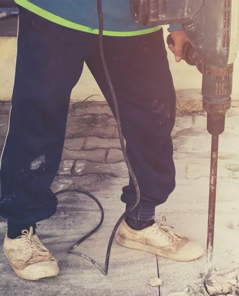 A contractor injecting polyurethane foam under a concrete slab.<br />
