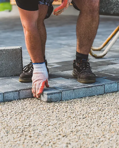 A contractor laying paving stones 