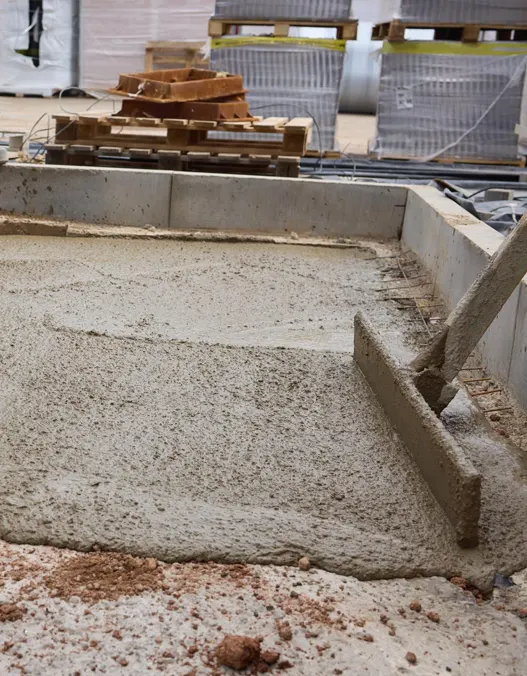 Construction workers leveling liquid poured concrete on a construction site