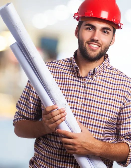 A contractor in a red hard hat holding a blueprint and smiling