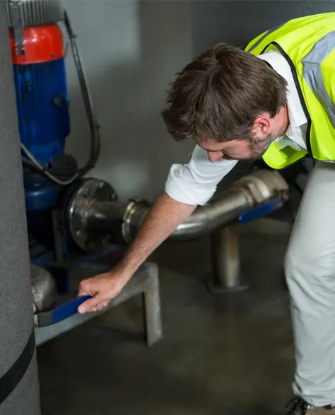 A man in a vest checking the working of a sump pump 