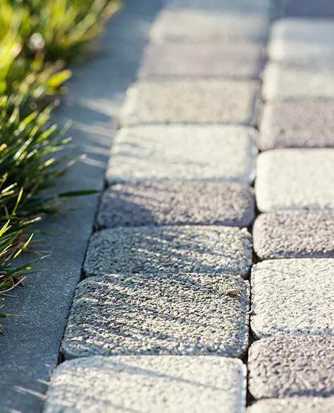 Patio Paver Installation: Patio area with natural grass on one side and patio pavers on the other.