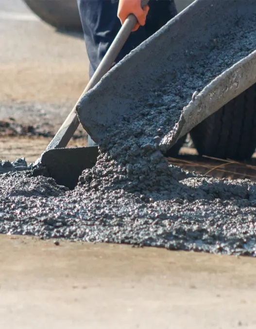 Professional construction workers laying liquid concrete for a concrete slab