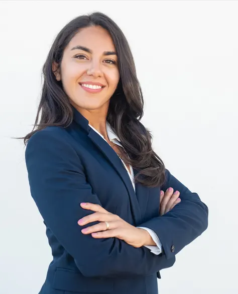 A smiling professional woman in business attire with folded arms<br />
