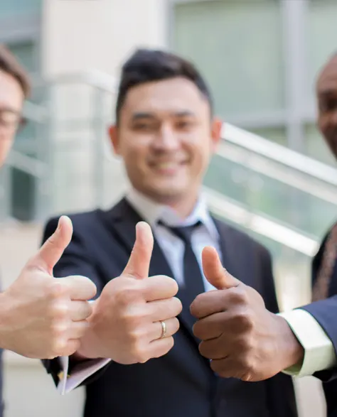 Three contractors in business suits giving a thumbs up