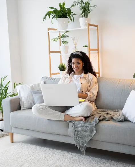 A woman sitting cozily on a couch in her comfortable and dry home 