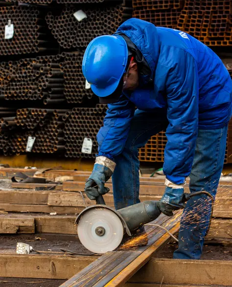 A contractor cutting a steel beam for structural reinforcement.