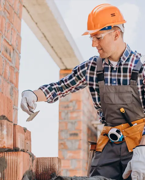 A contractor doing repair work on the foundation of a house