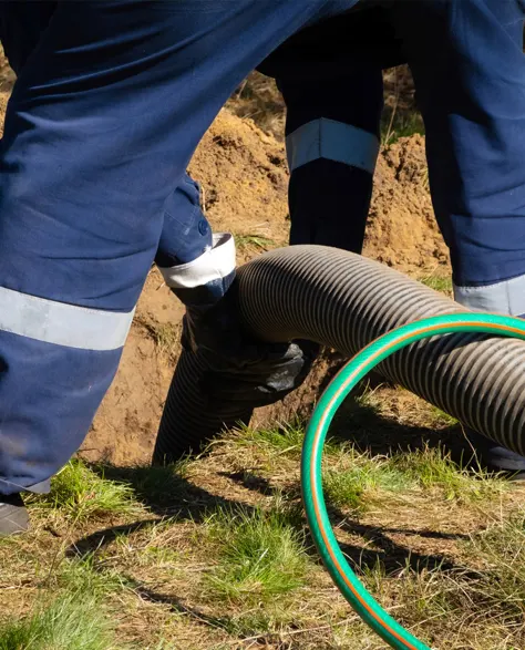 A contractor installing an exterior French drain system