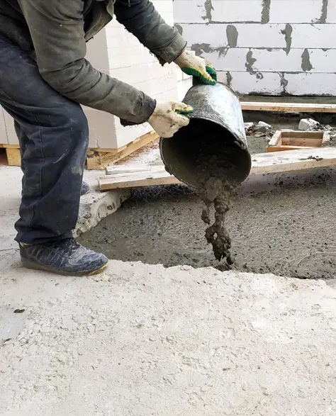 A contractor laying liquid cement for underpinning