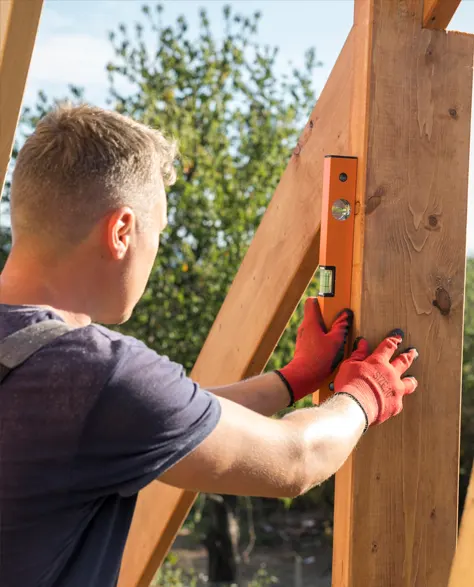 A contractor measuring a wooden beam in a residential renovation project.<br />
