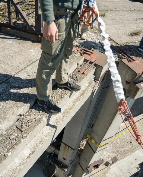 A close-up of a contractor placing a concrete support beam for underpinning.