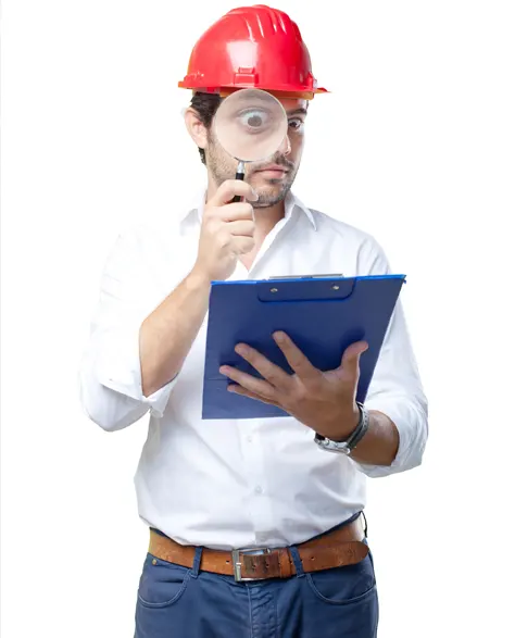 A contractor in a hard hat using a magnifying glass to study the lally column design on his clipboard