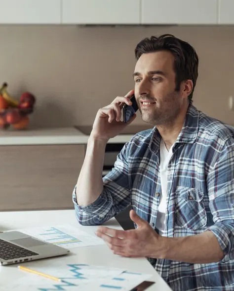 A homeowner on the phone scheduling a yard drainage installation appointment.