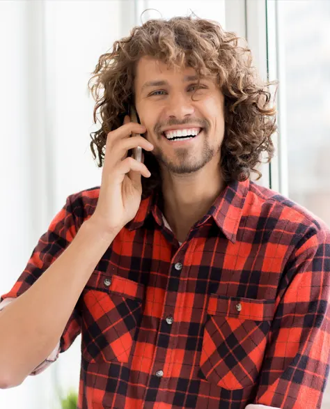 A man happily talking on the phone to book a consultation 