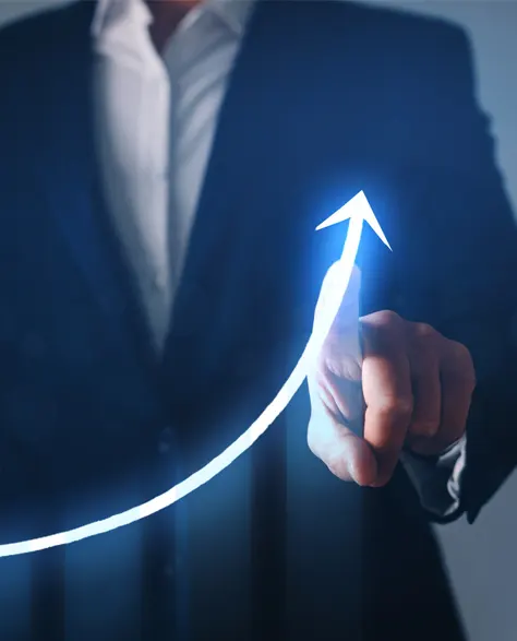 A man in a suit points to an arrow of a graph that is going up