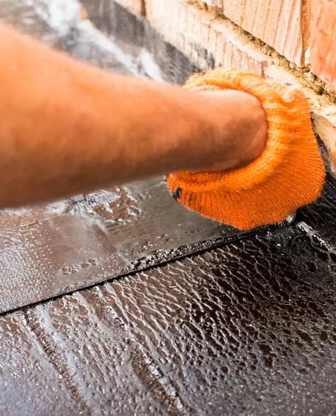 A professional contractor applying waterproofing membrane on the roof