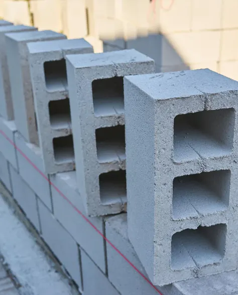 Concrete blocks laid along a property where they will be used for retaining wall installation.