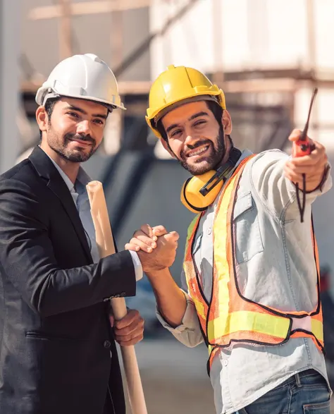 two contractors on the construction site shaking hand 