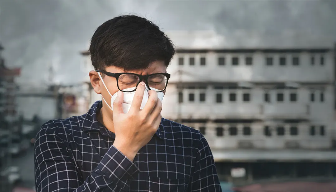 A man wearing a mask to avoid the smell