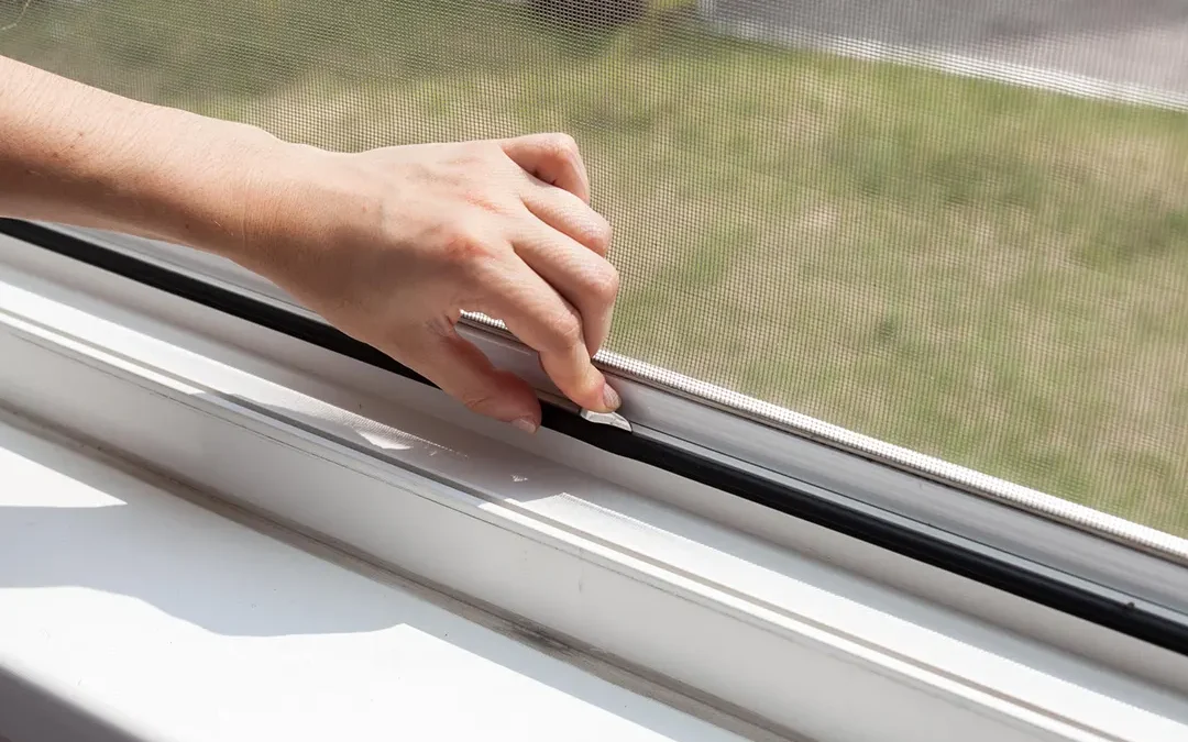 A man trying to open a sticking window