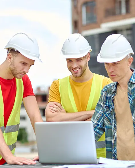 Three contractors looking at their laptop