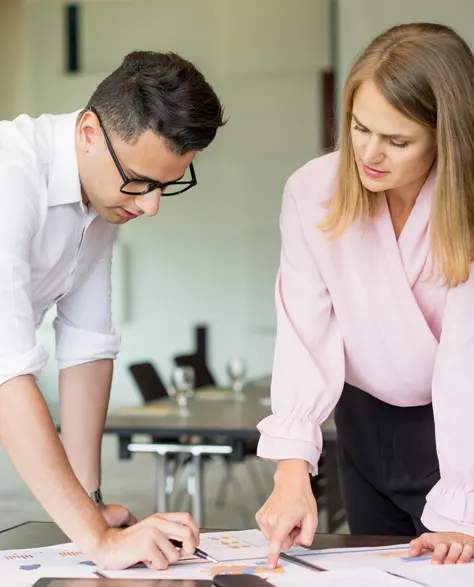 Two contractors working on a project and discussing on paper in an office setting 