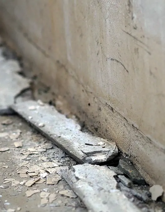 Water damage, cracks and spalling on the concrete foundation surface