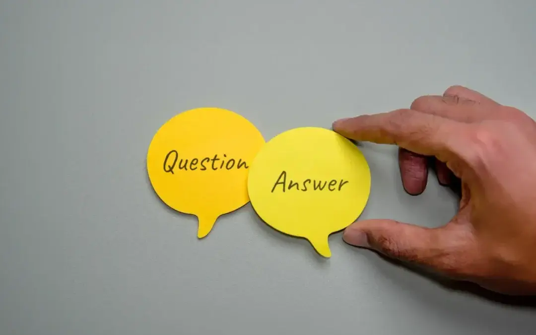 How Often Should a Sump Pump Run? - A Man's Hand Placing an Answer Chat Bubble Near a Question Chat Bubble on a Table