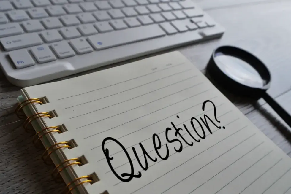 Do I Need a Sump Pump? A Notebook Sitting in Front of a Computer Keyboard with "Questions" Written on it