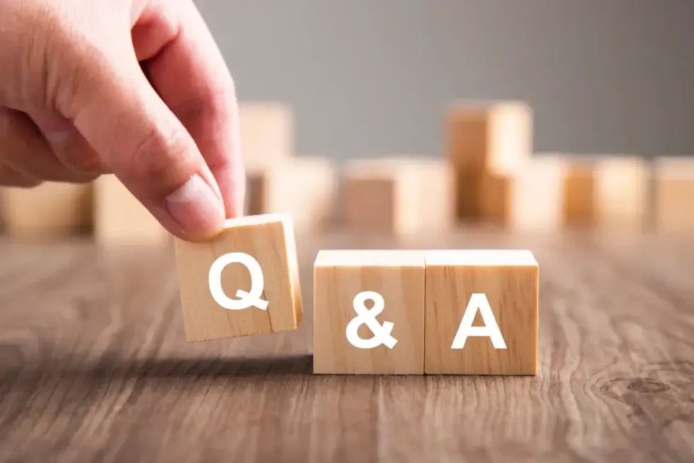 Is Spray Foam Waterproof? A Man Placing Blocks of Wook on a Table That Say Q and A