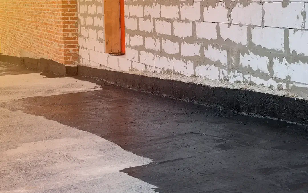 Exterior basement waterproofing - a contractor laying a waterproofing agent on the exteiror of property in Long Island,