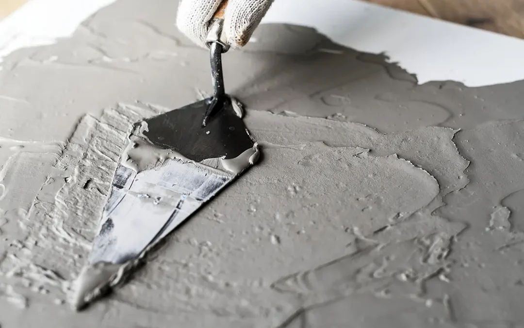 A contractor patching concrete with a trowel