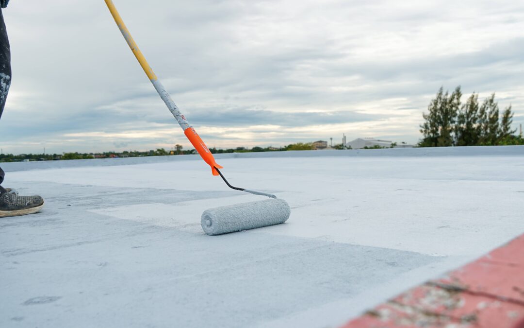 A contractor waterproofing a roof using a roller
