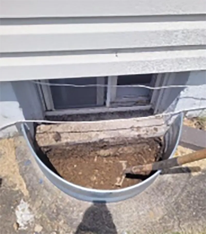 Damaged basement window and poorly drained window well before repair in Hicksville, NY home.