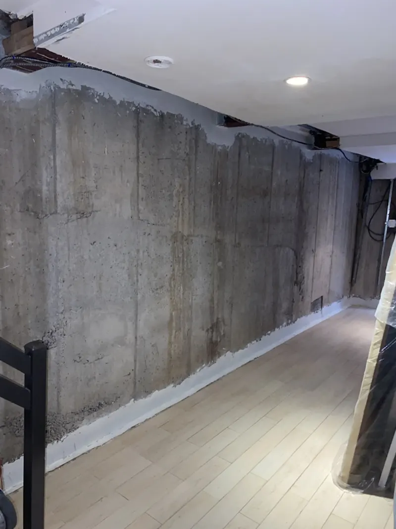 Basement Foundation Waterproofing – Greenpoint Ave, Brooklyn, NY – A Room with a Waterproof Seal Around the Top and Bottom of the Wall
