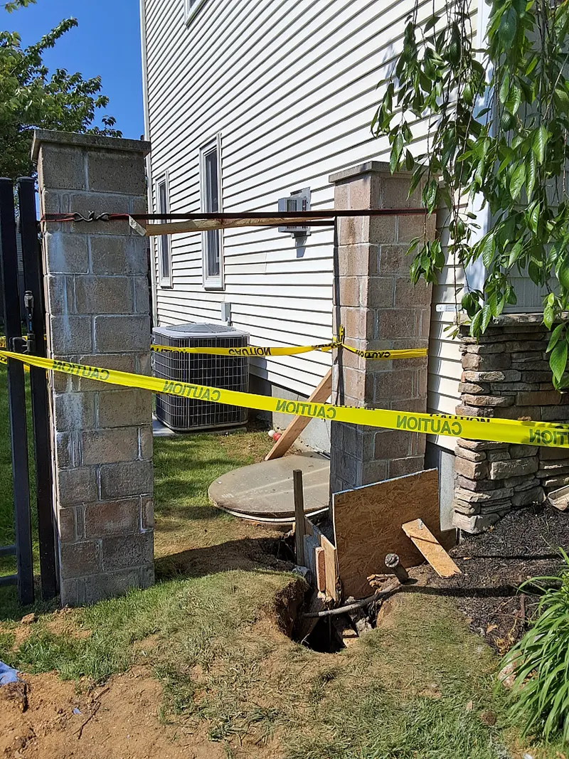 Stone Fence Column Repair in Oceanside, NY - A Hole Dug Around a Stone Column with Temporary Supports in Place