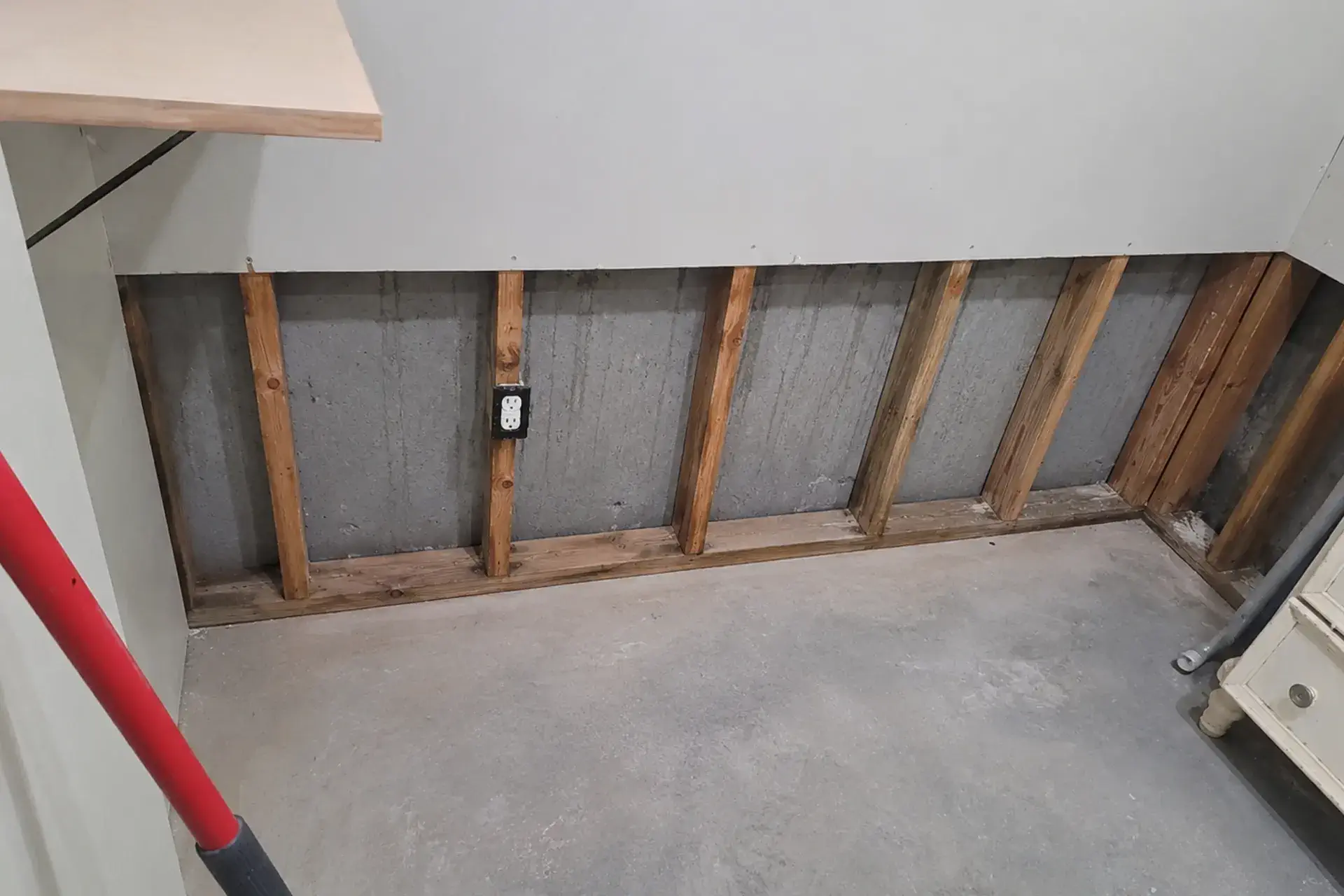 basement-wall-after-mold-remediation-featured Professional mold remediation project in Brentwood NY showing removed contaminated drywall, exposed basement wall structure, and disinfected surfaces prepared for waterproofing evaluation.