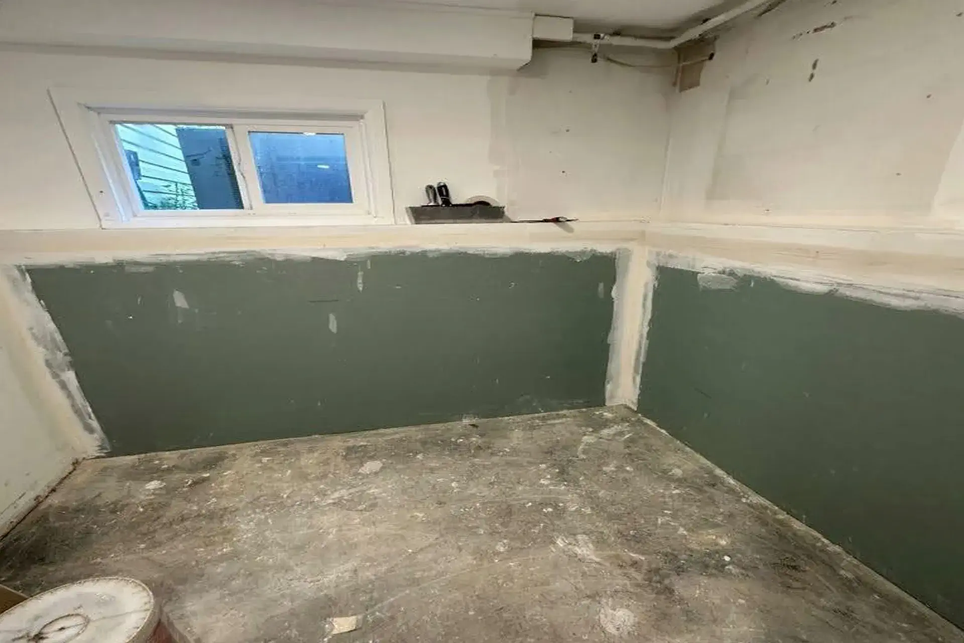 completed-basement-waterproofing-and-structural-repair-featured Completed basement waterproofing and structural repair project in Huntington NY showing restored basement walls, mold remediation, garage dry well drainage system, and new steel support column installation.