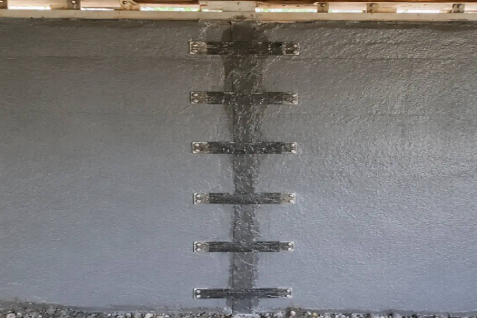completed-structural-crack-repair-featured Structural crack repair project in Rocky Point NY with carbon fiber stitching, epoxy injection, and reinforced waterproof foundation wall below a spandrel beam.