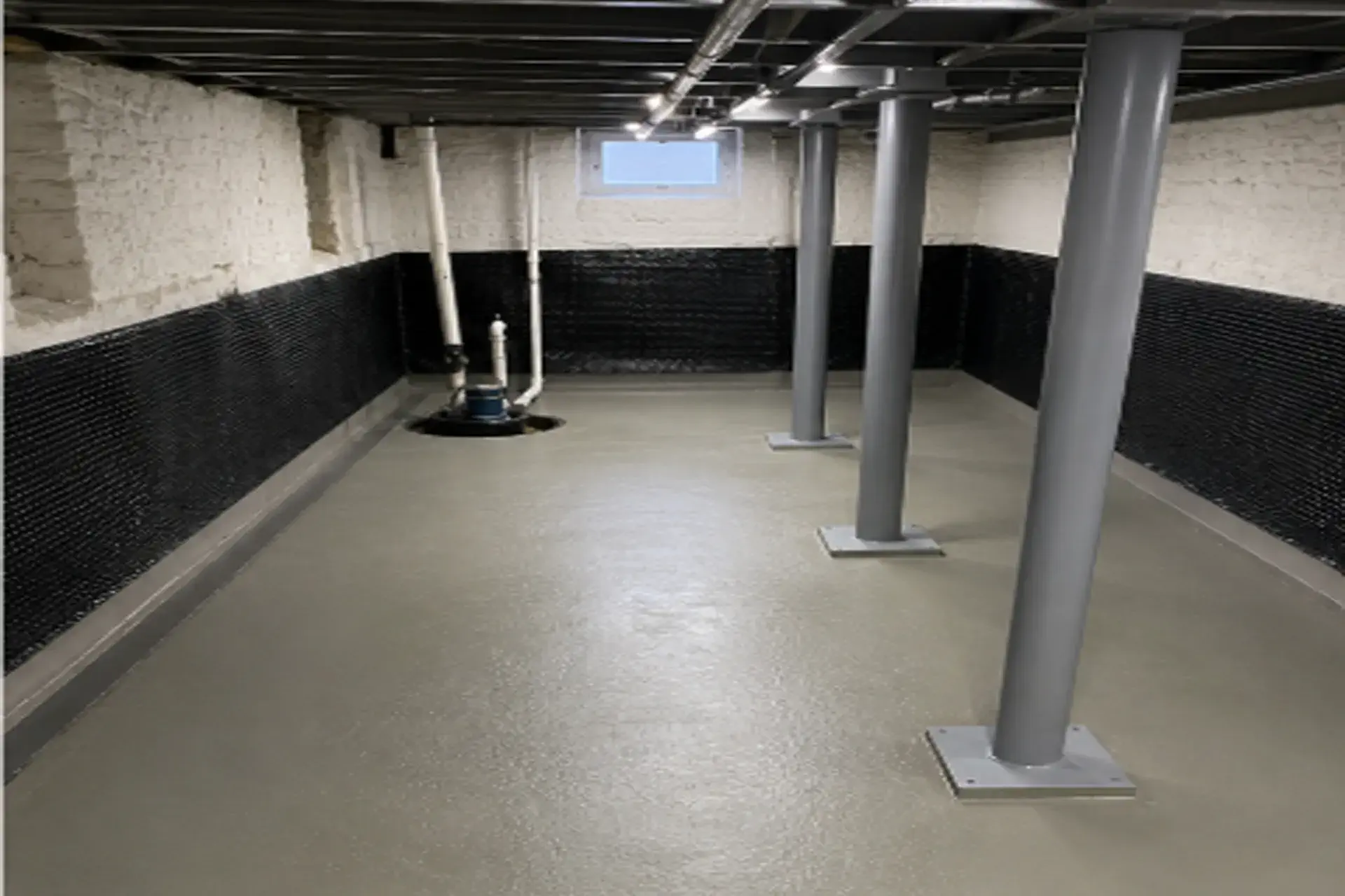 finished-basement-waterproofing-project-featured Completed basement French drain replacement and waterproofing project in East Setauket NY with restored concrete floor and new drainage system.