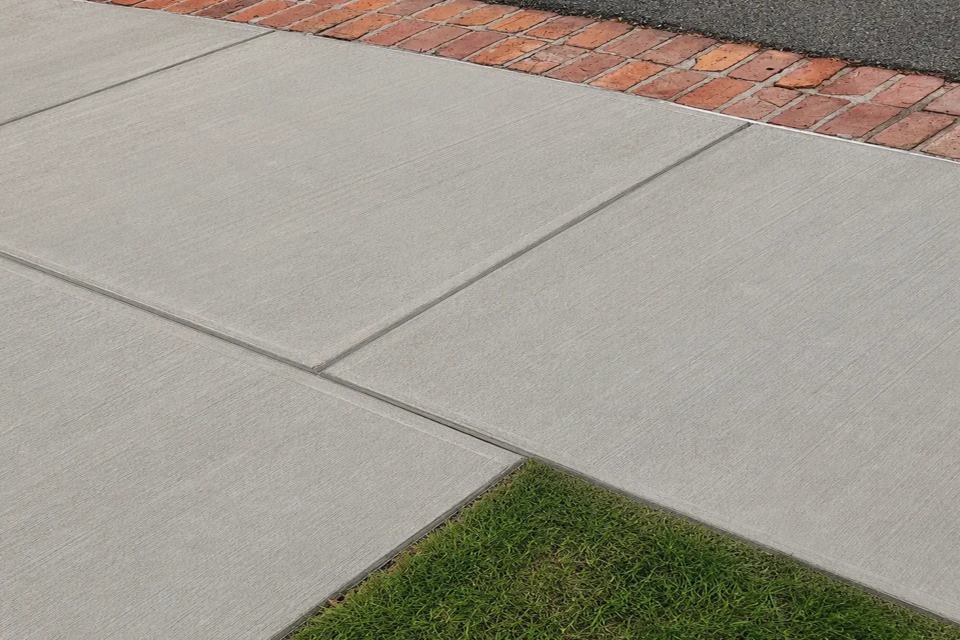 new-reinforced-concrete-walkway-installed-featured Completed sinkhole repair and reinforced concrete walkway restoration in Woodbury NY with compacted soil, crushed stone base, and new concrete surface.