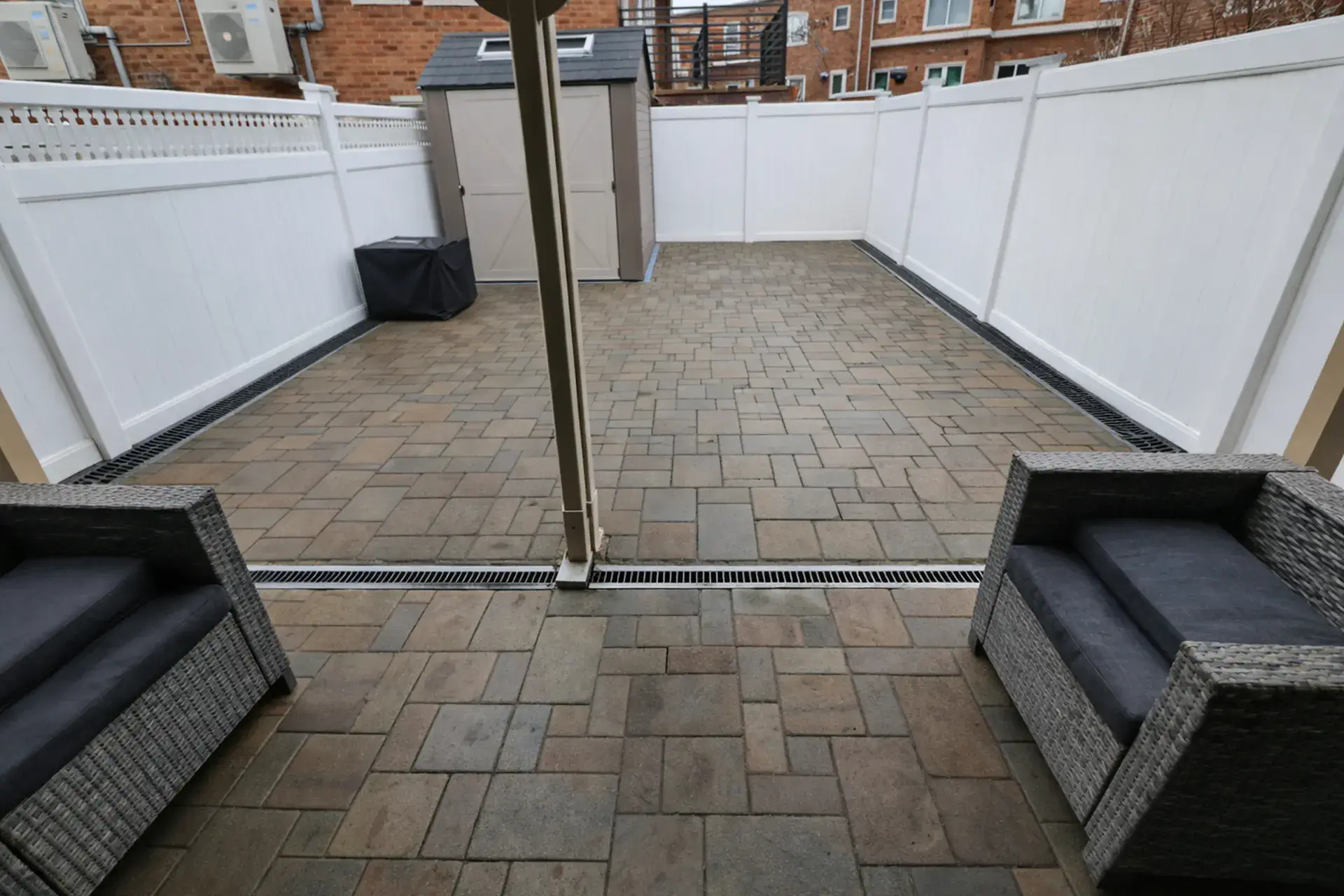 patio-trench-drain-featured Patio trench drain installed along brick paver patio wall to prevent water runoff in Middle Village NY