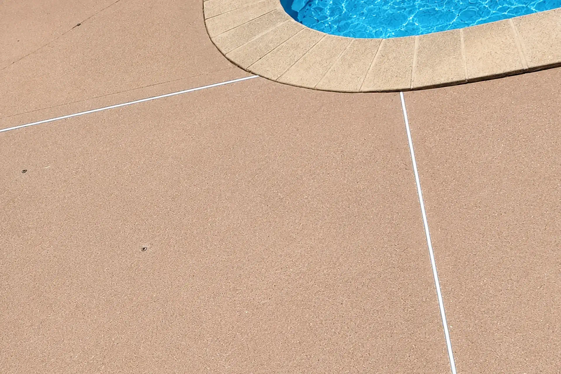 restored-level-concrete-slab-near-swimming-pool-featured Concrete slab lifting and mud jacking repair near swimming pool in Calverton NY showing restored level concrete surface after void filling.
