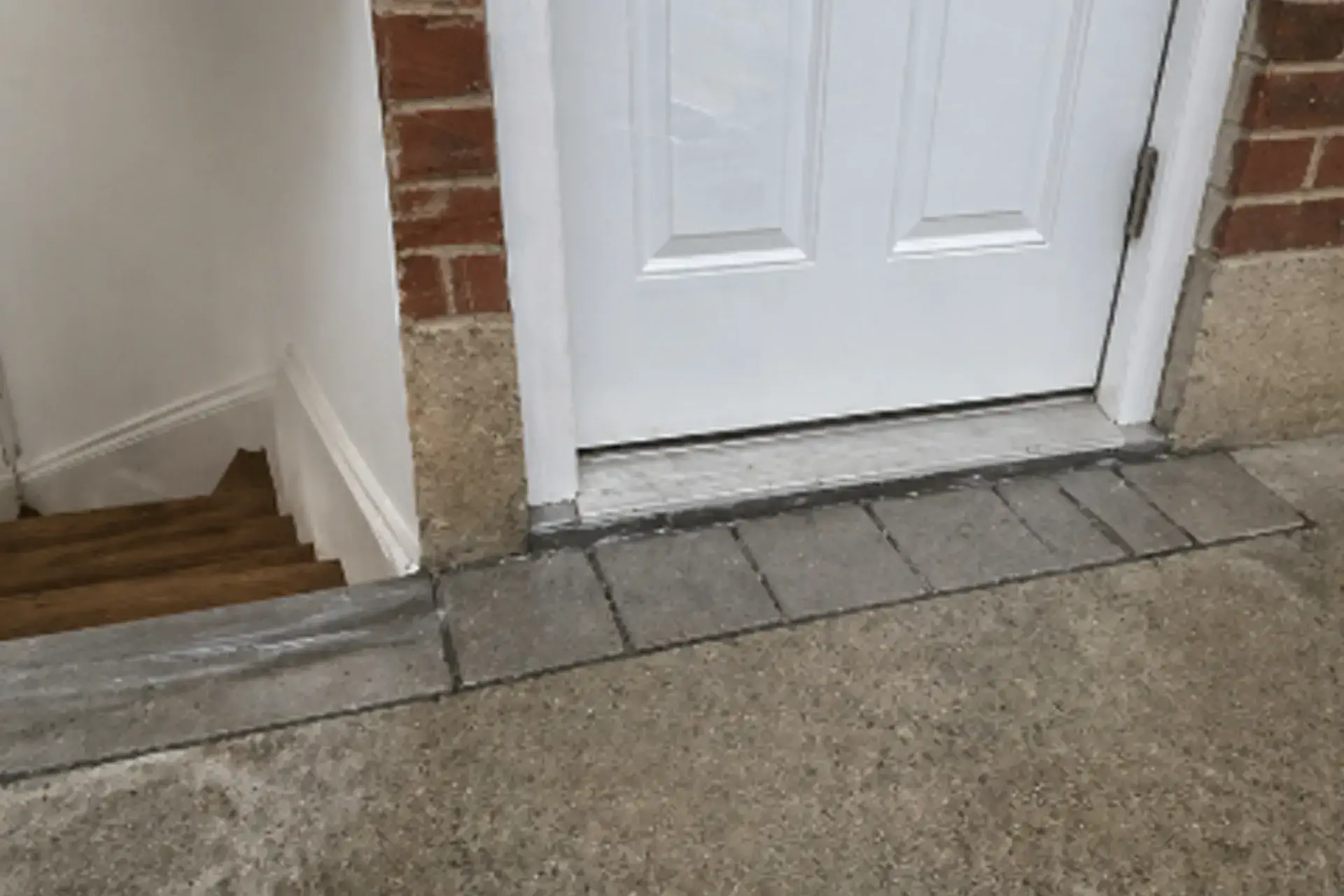 side-entrance-waterproofing-completed-sealed-door Bayside NY side entrance waterproofing completed sealed door saddle restored pavers clean entry exterior water intrusion fixed drainage improvement system integrated