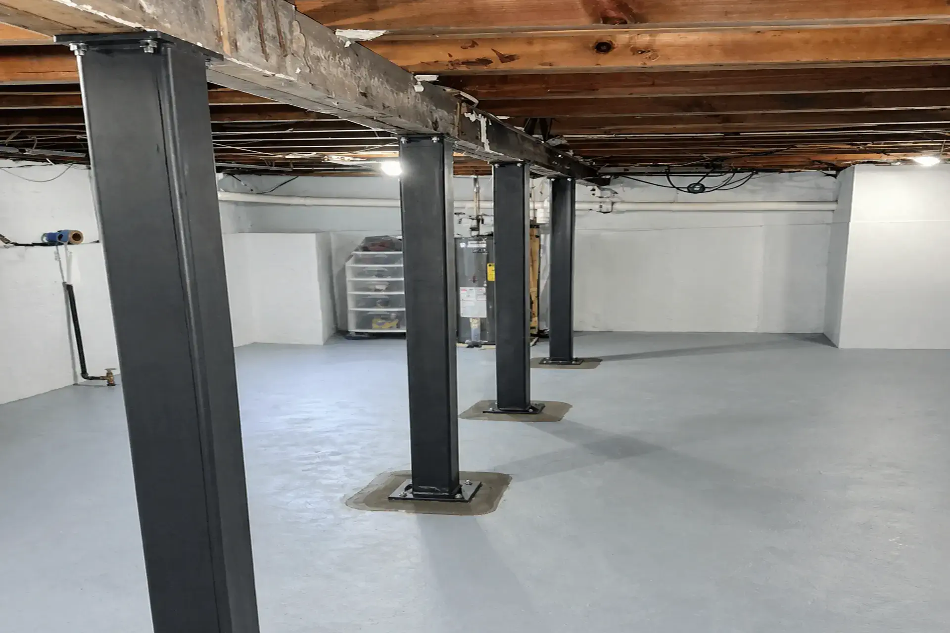 steel-basement-support-columns Steel basement support columns installed in Smithtown, NY replacing damaged wooden posts for improved structural stability.