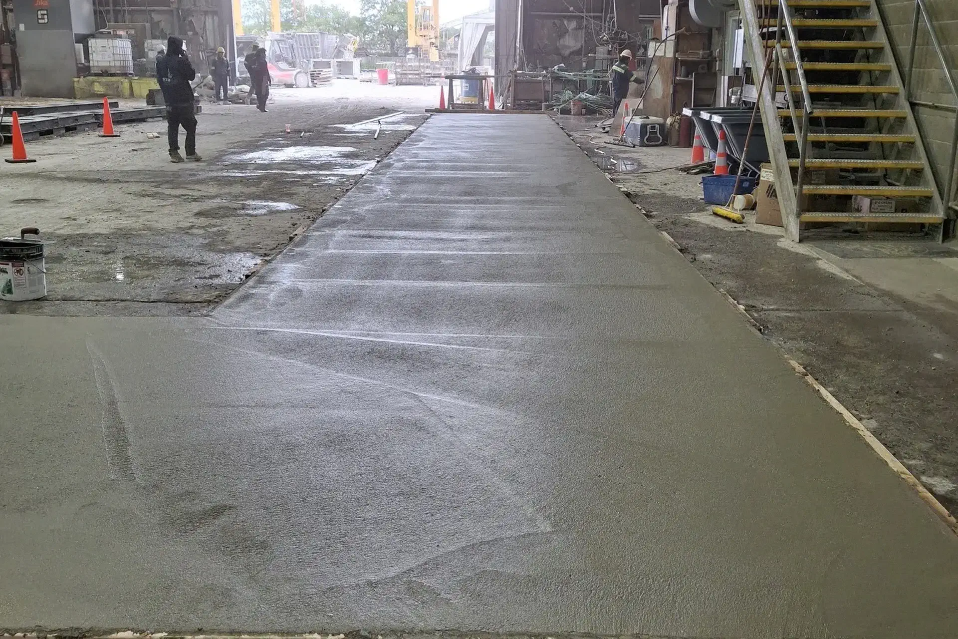 finished-reinforced-concrete-featured Completed reinforced concrete overlay and leveling project on a 100-foot industrial concrete slab in Bay Shore, NY, prepared for steel plate installation.