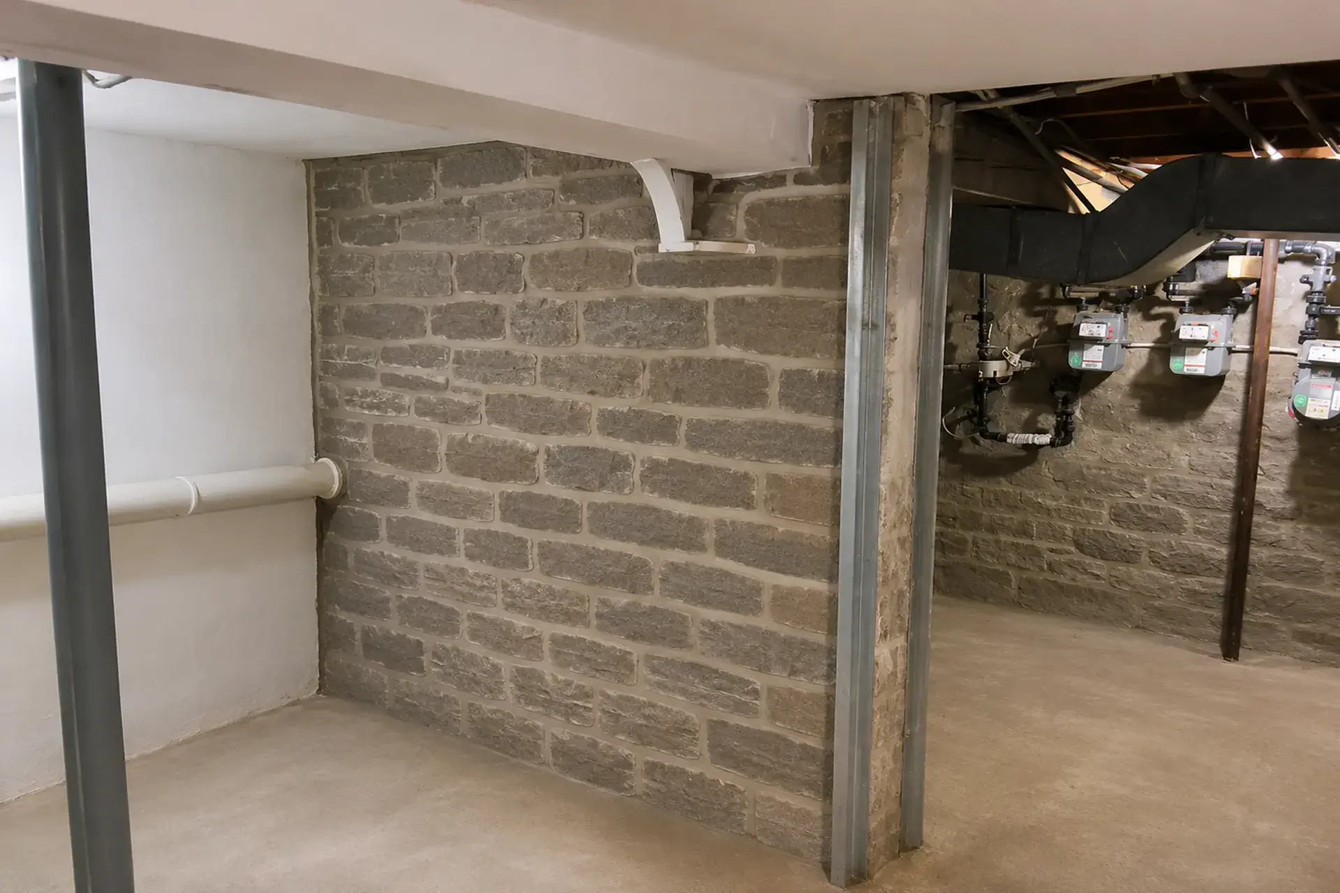 repaired-basement-foundation-wall-featured Repaired basement foundation wall with restored mortar joints and waterproofing cement applied in Brooklyn, NY.