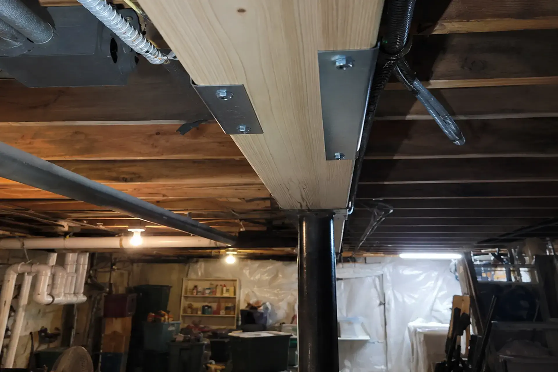 repaired-floor-joists-and-reinforced-wooden-support-beam-featured Repaired floor joists and reinforced wooden support beam restoring structural stability in a Brooklyn, NY basement.