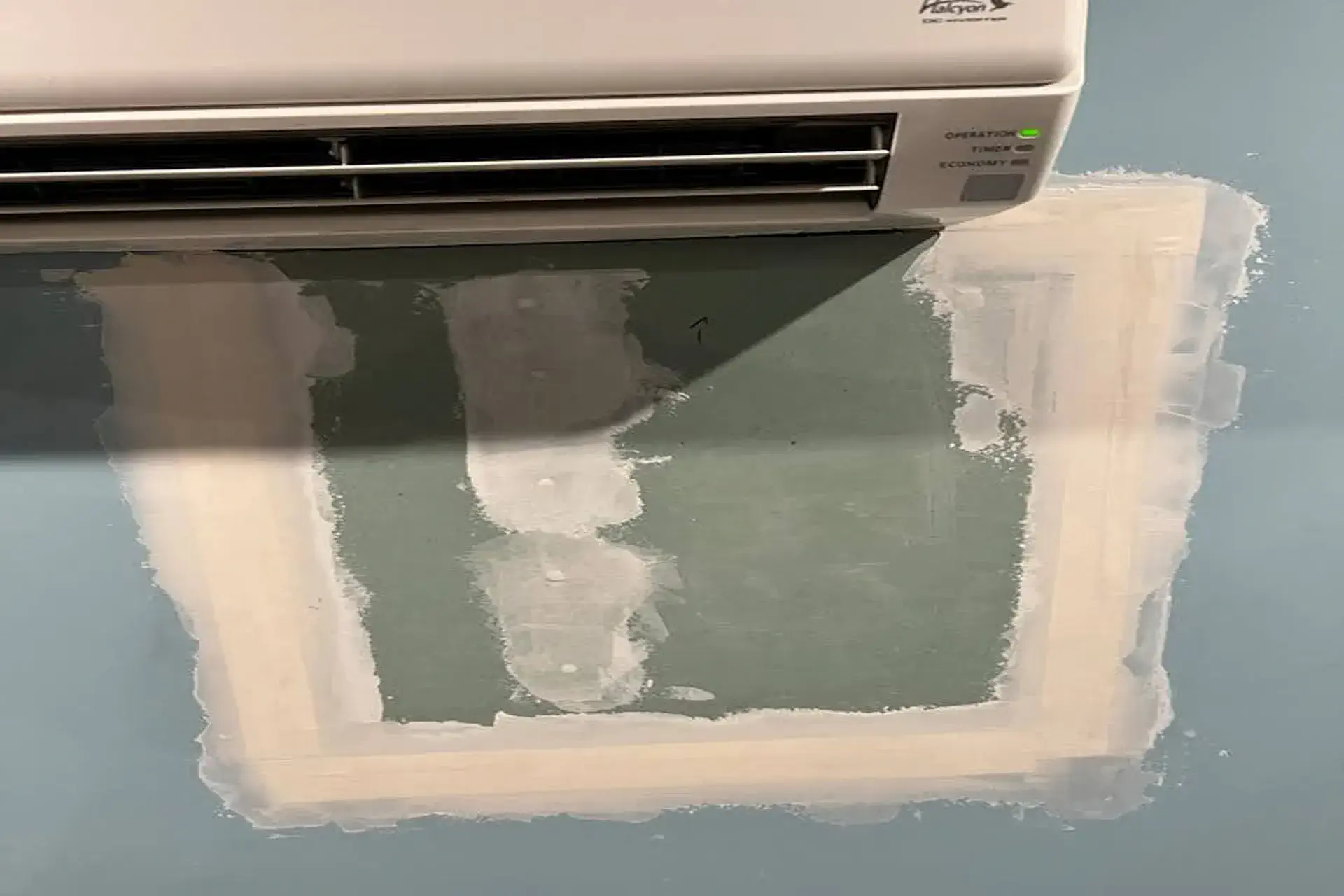 completed-wall-repair-featured Restored wall beneath a split-unit HVAC system after water intrusion repair in Huntington NY.